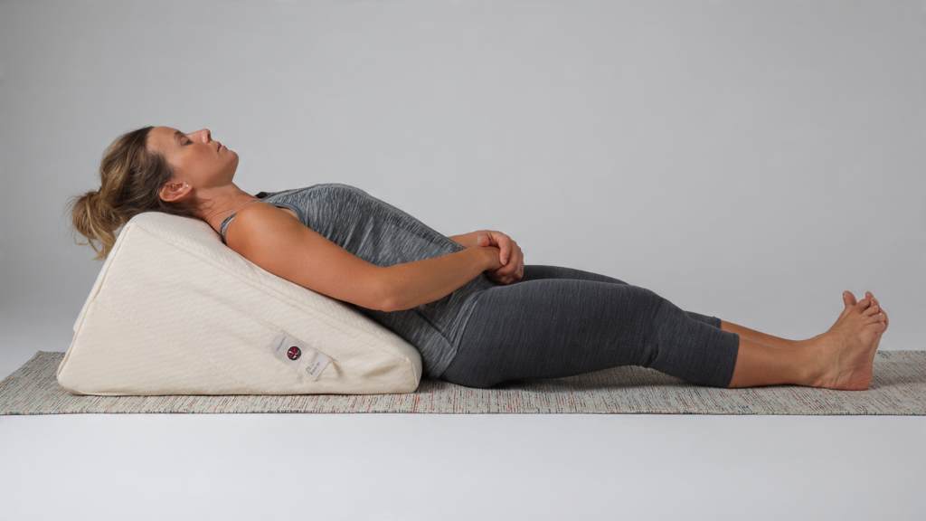 Side view of a versatile wedge pillow used for leg elevation, showing spinal alignment benefits for back pain.
